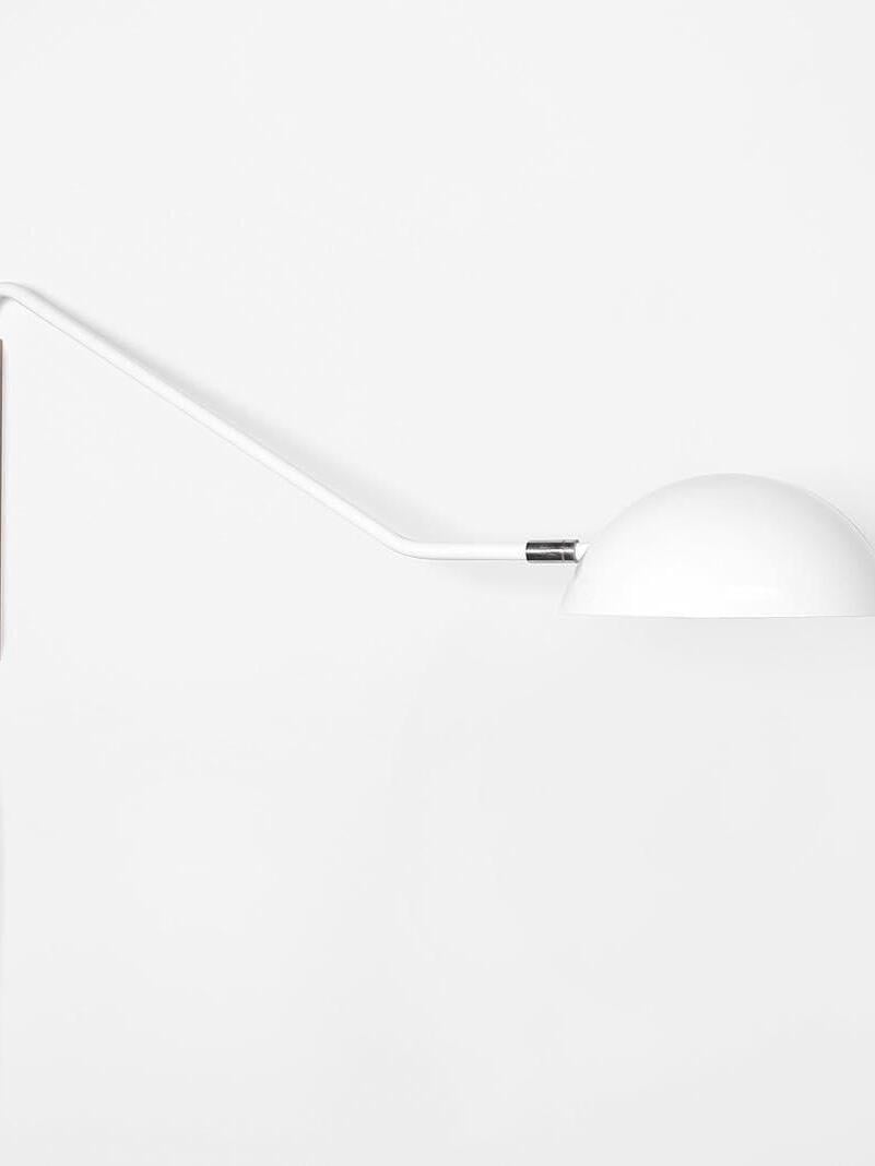 White dome shade and white angular arm close-up, with a silver-tone joint against a pale background
