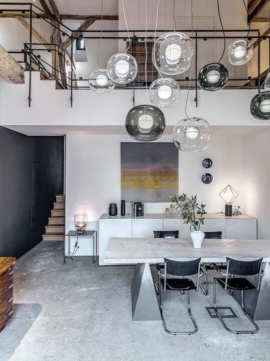 Large glass pendant arrangement above a dining room