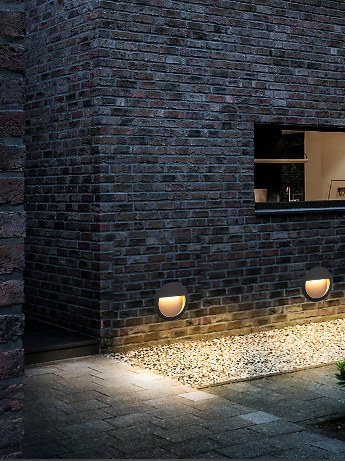Two low round lights on brick exterior wall