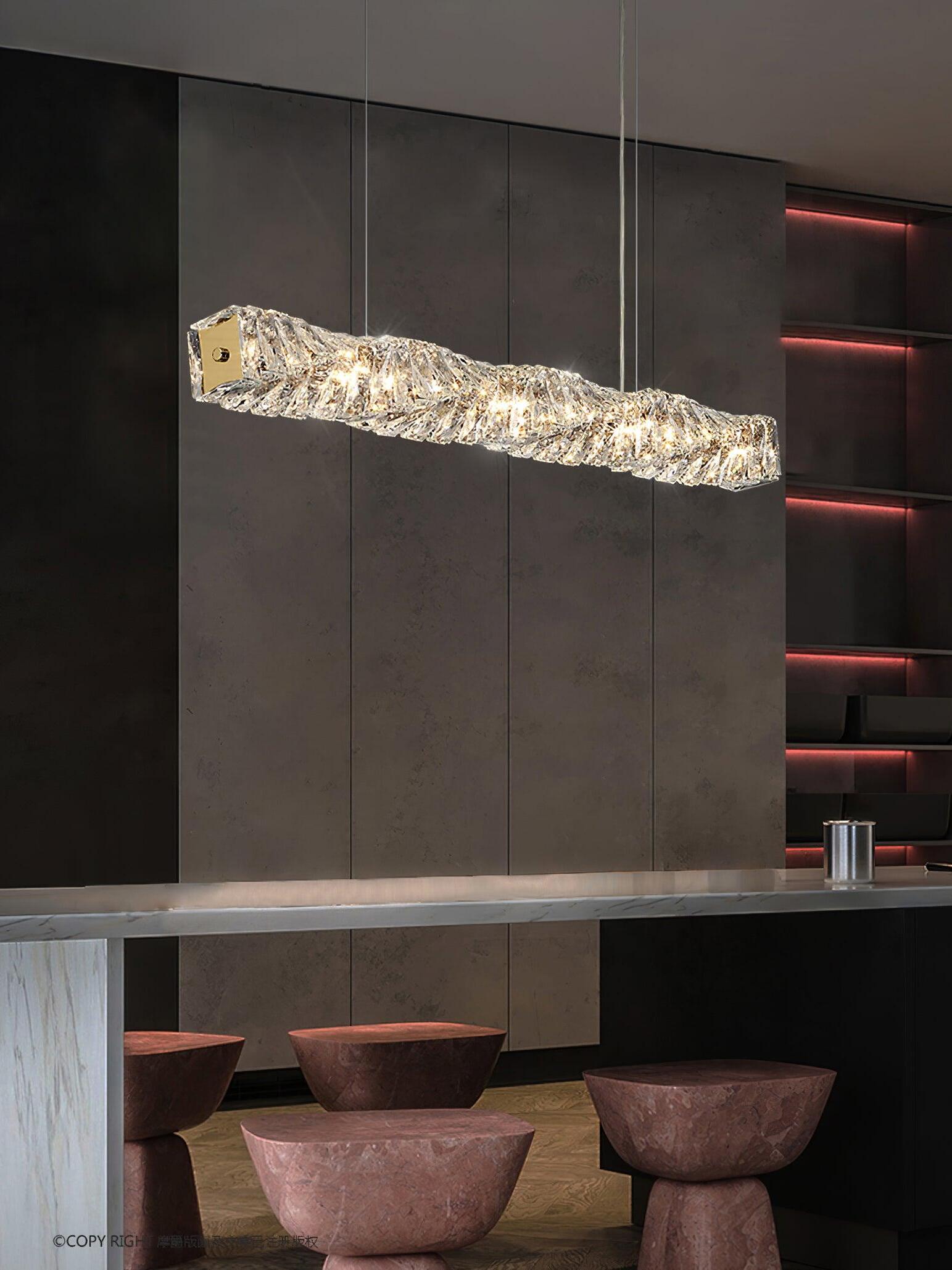 Long crystal pendant above a dark counter with pink stools and red-lit open shelving