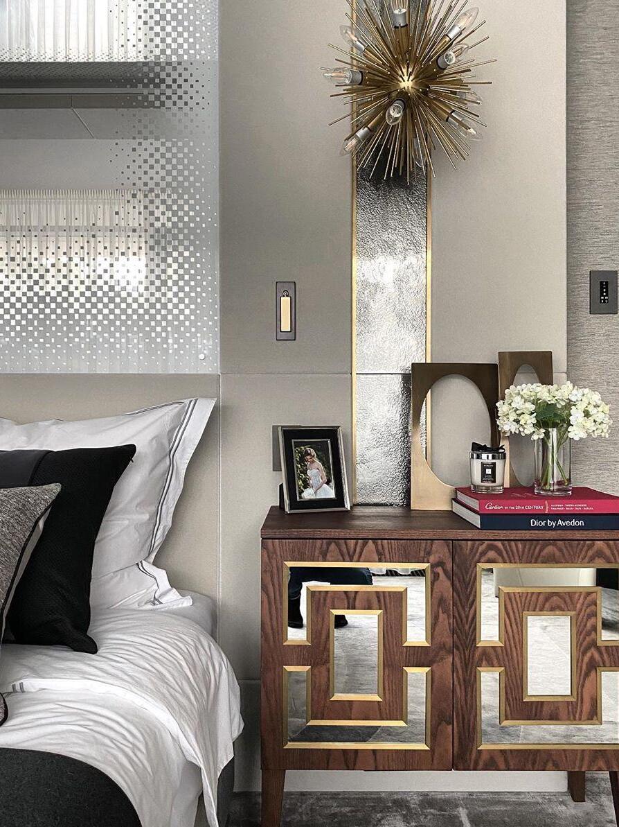 Small reading fixture near framed bedside pictures