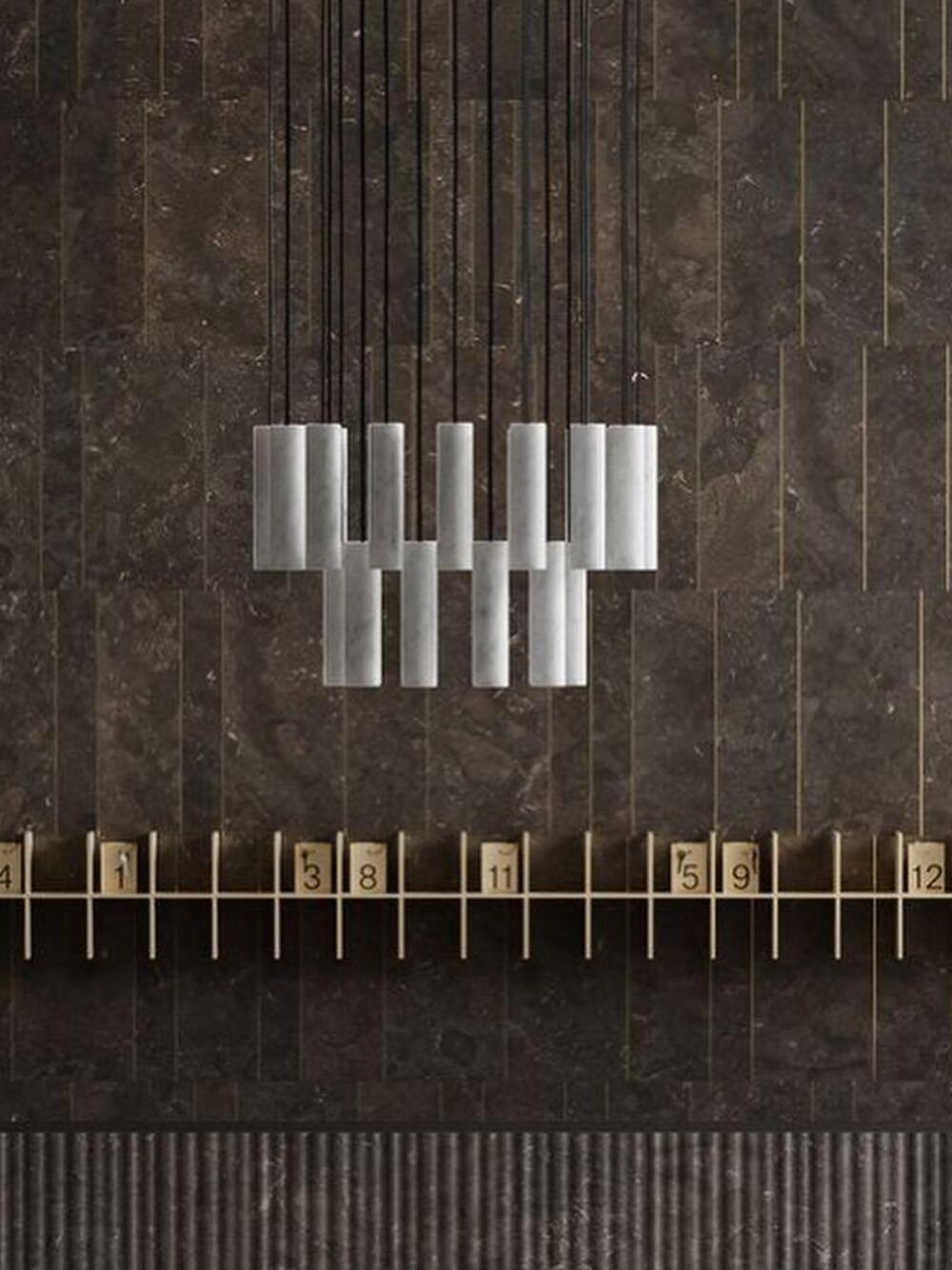 Unlit Silo cylinder cluster in front of a dark panelled wall and numbered shelf