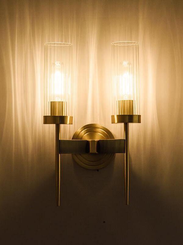 Warmly lit twin candle-style stems against a wall