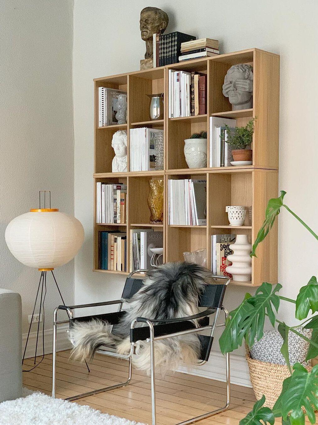 Paper floor lamp near bookcase and armchair