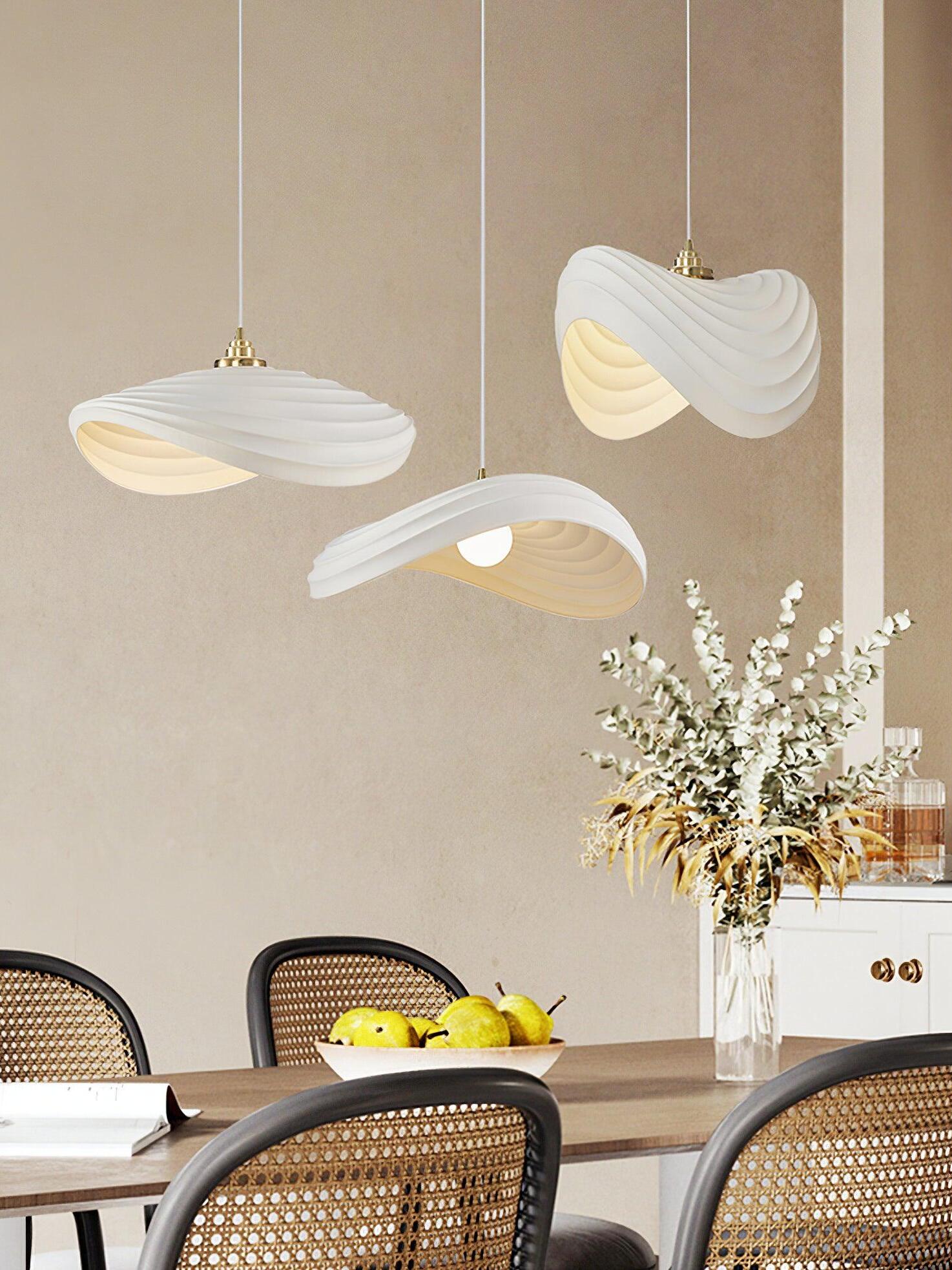 Three White Navicula pendants over dining seating