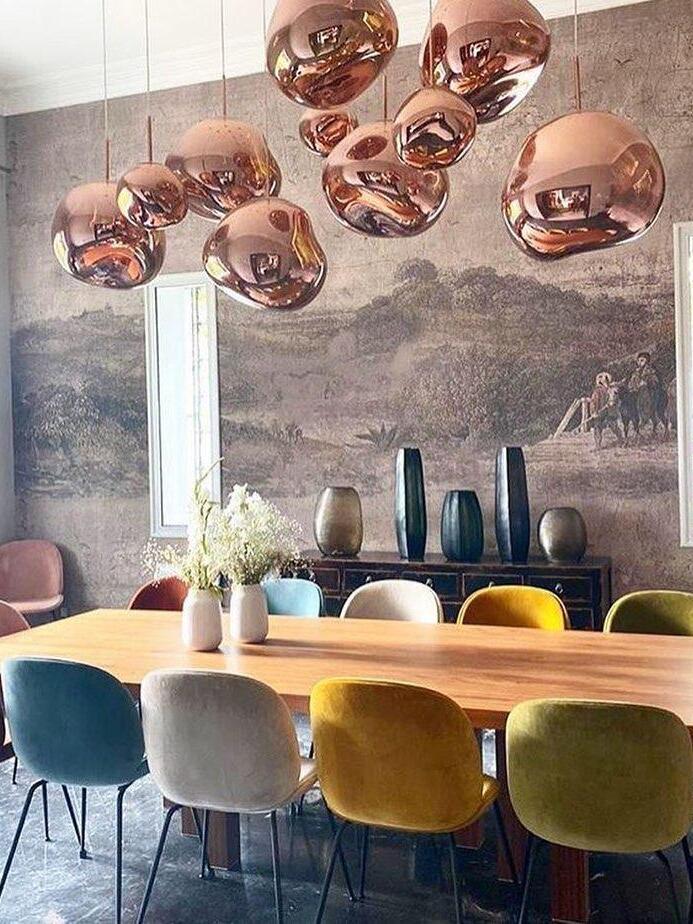 Several reflective shades above a long dining table