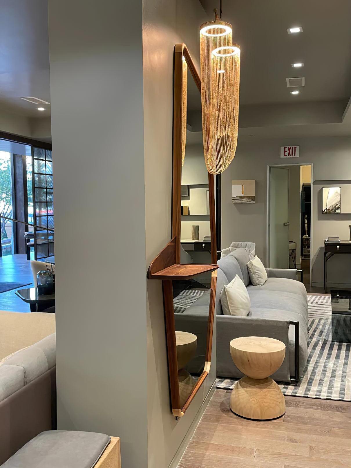 Tall chain pendant beside a mirror in a showroom