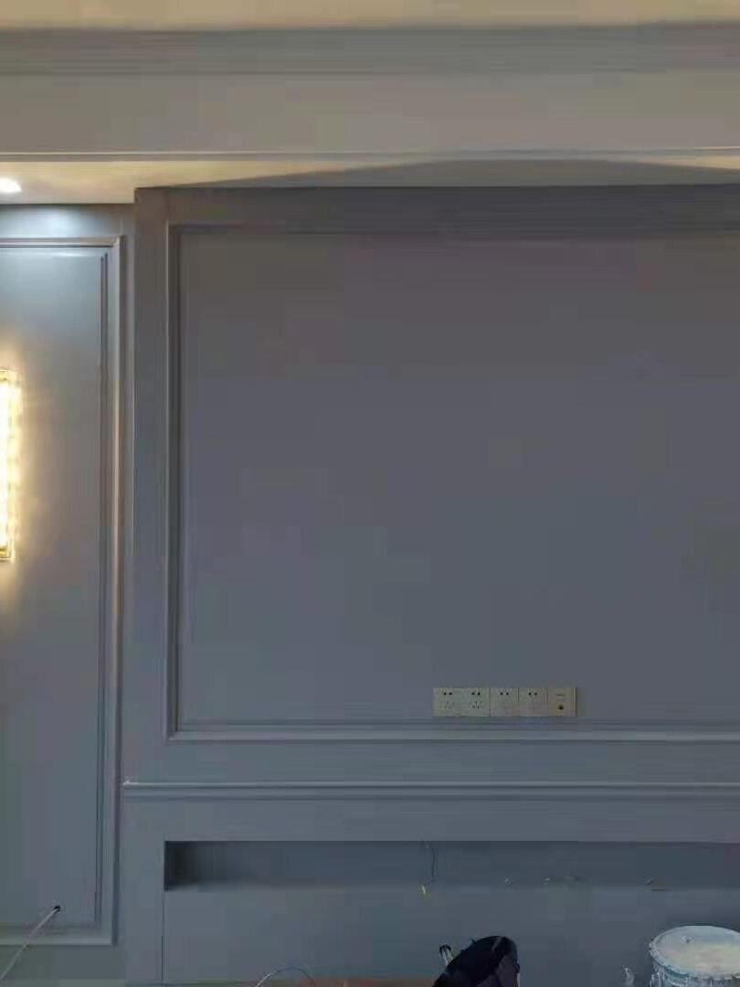 Partly cropped glass wall light at edge of grey panel