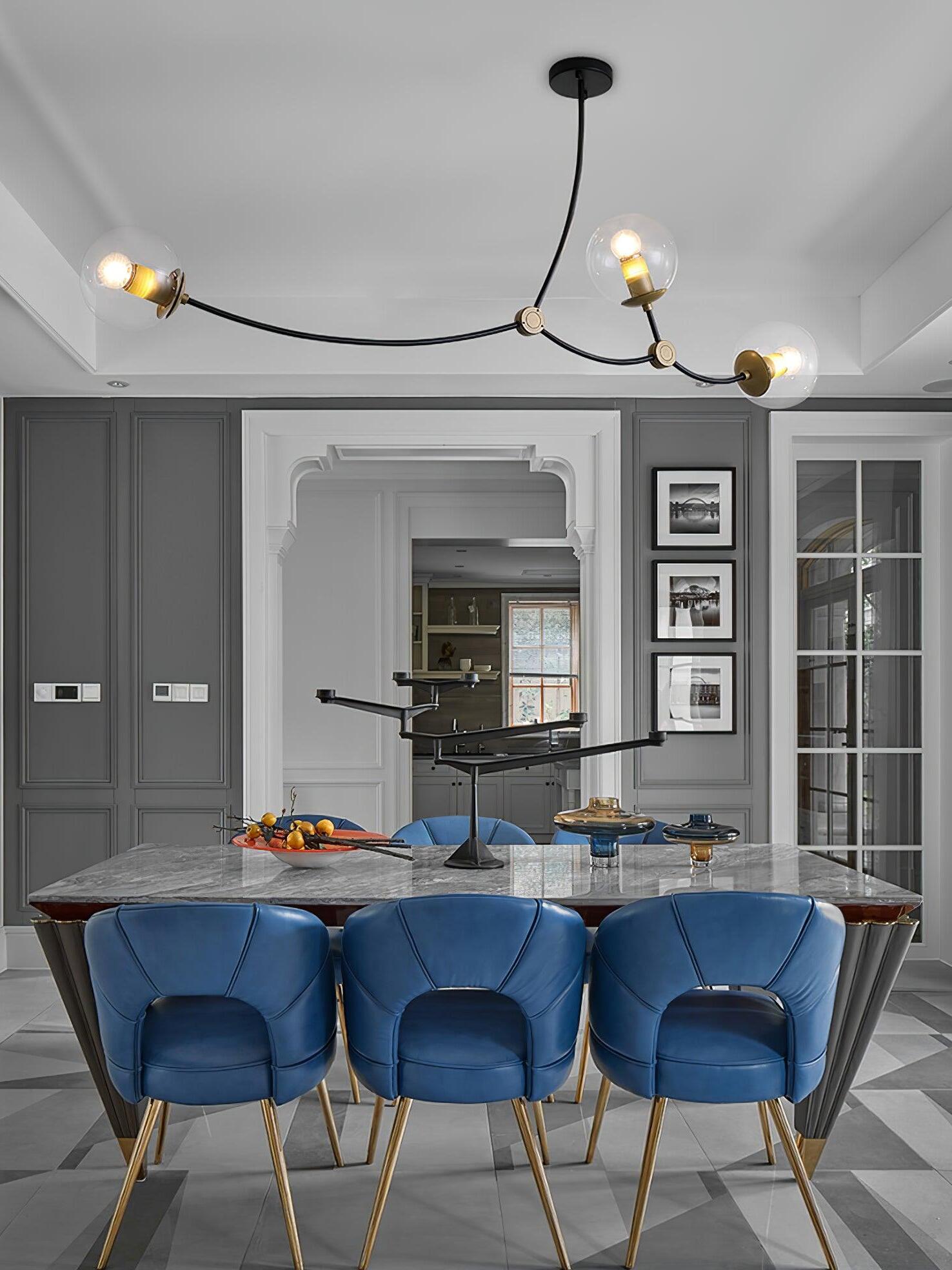 Clear-globe chandelier above blue dining chairs