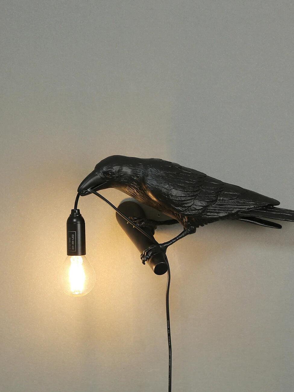 Opposite-side view of the black bird with a labelled holder, lit bulb and descending cable
