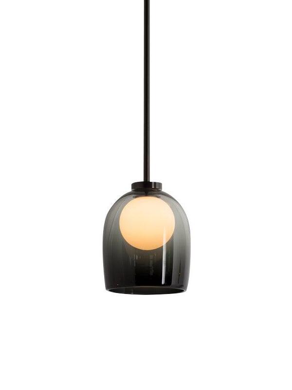 Gradient-black Crux pendant with a glowing sphere and dark cord against a white background
