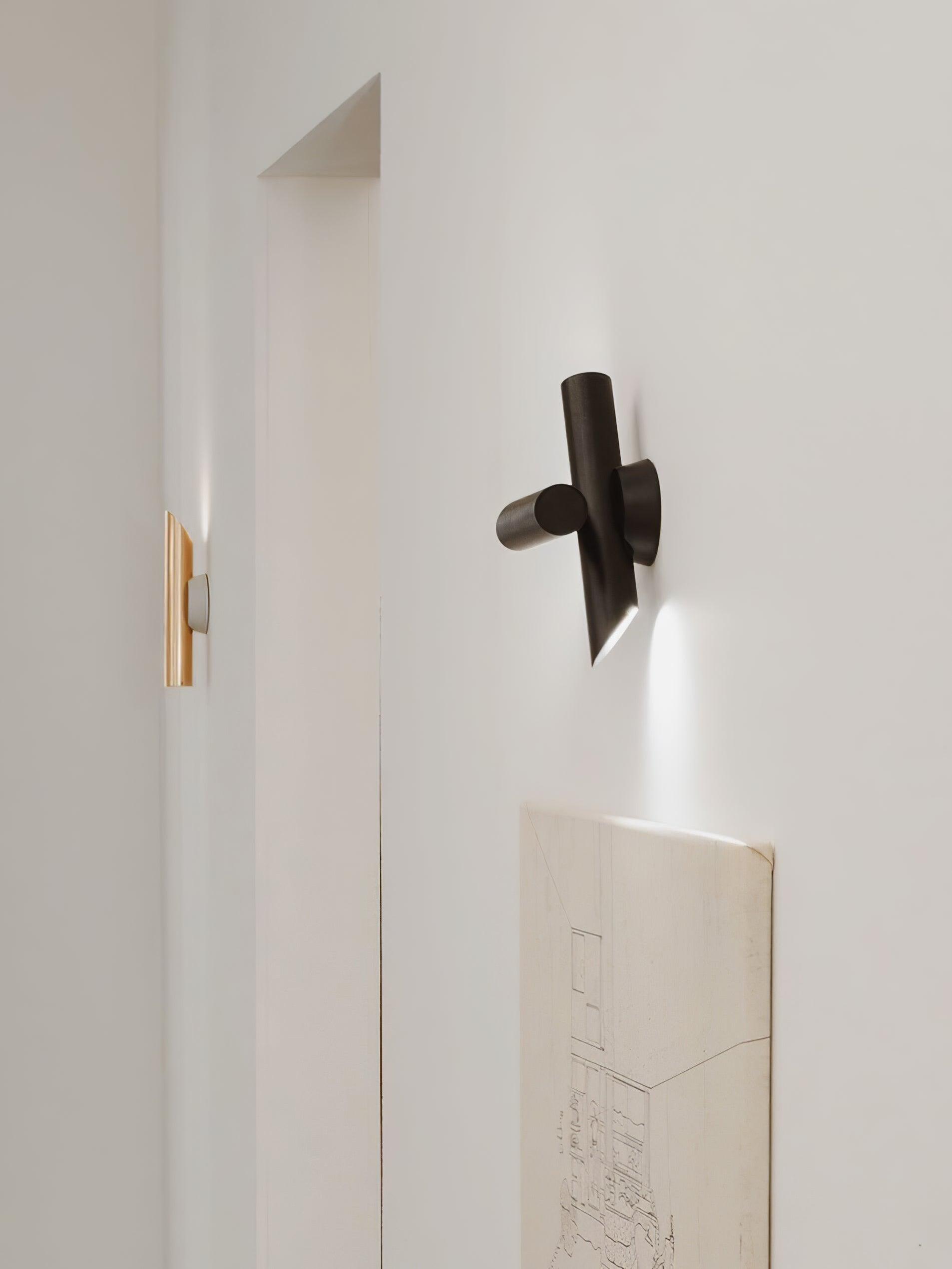 Black wall light on white wall beside doorway