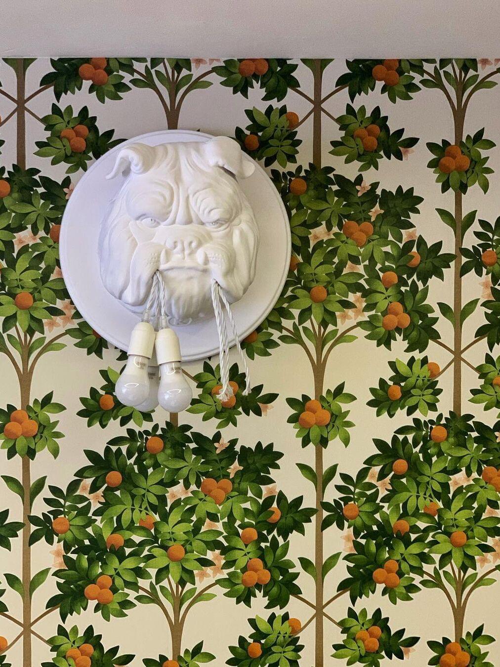White bulldog wall light against floral wallpaper