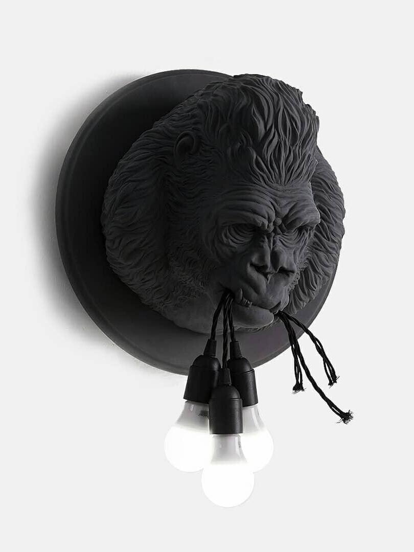 Isolated dark gorilla head with black cords and round exposed bulbs
