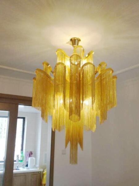 Gold chain-fringe chandelier illuminated