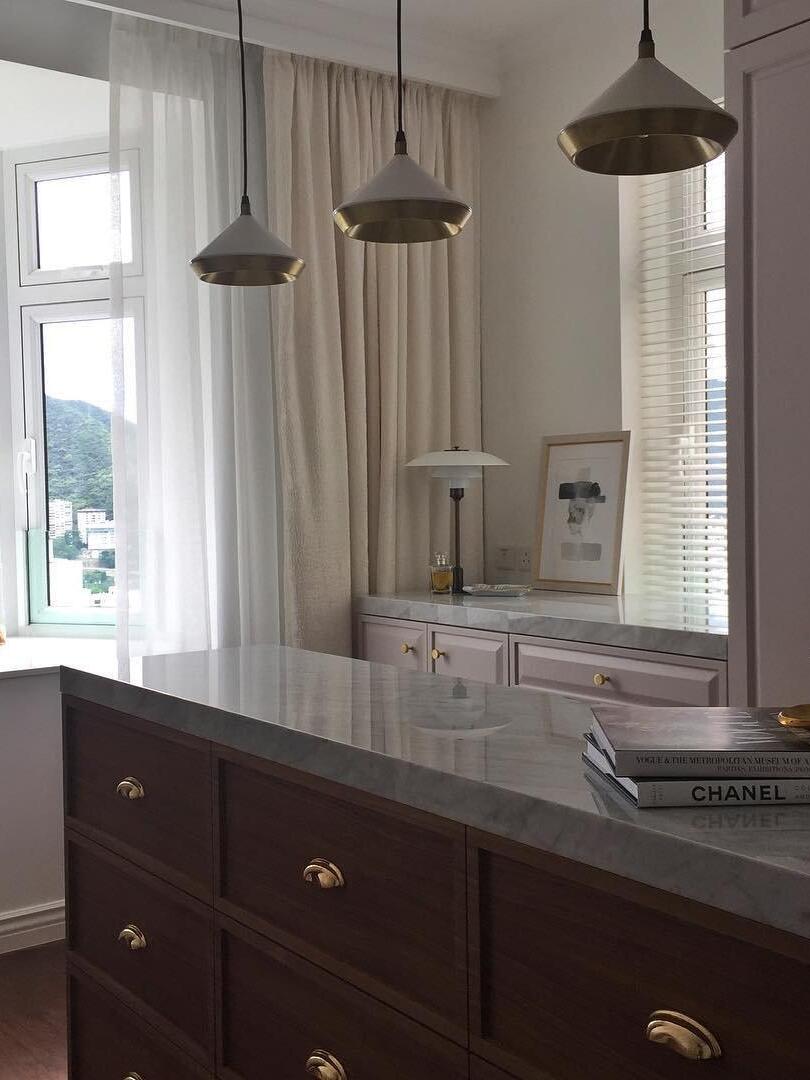 Three dark cone pendants along a kitchen counter