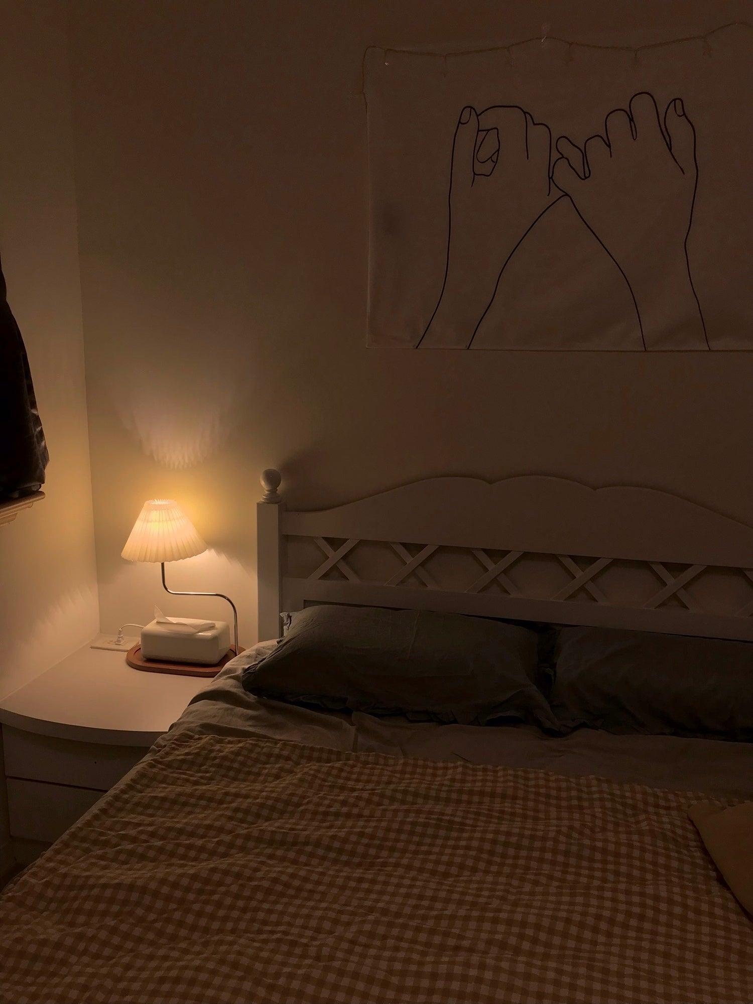 Small glowing bedside lamp in dark bedroom