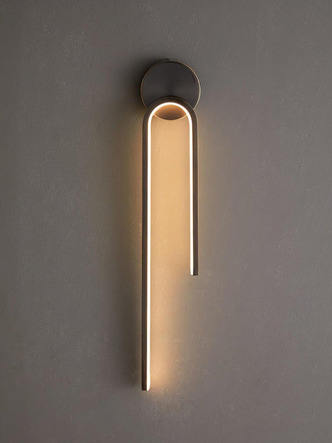 Dark asymmetric arch casting a warm-looking glow on a textured gray wall