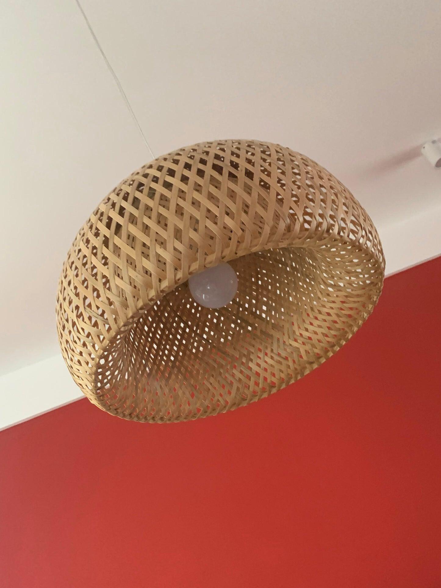 Upward view of open woven shade and inner bulb