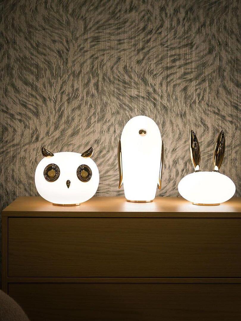 Closer lit owl, penguin and rabbit on wood sideboard