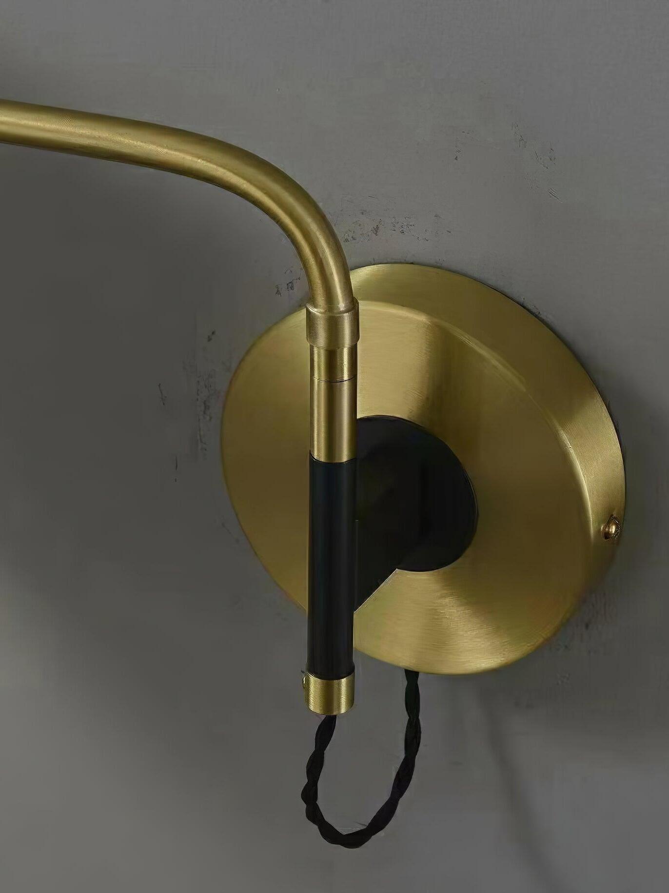 Close brass-tone round plate and arm joint with cable loop