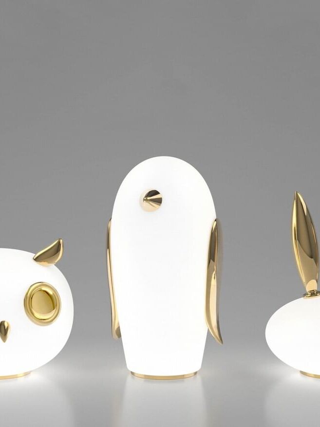 White penguin between cropped owl and rabbit on pale reflective surface