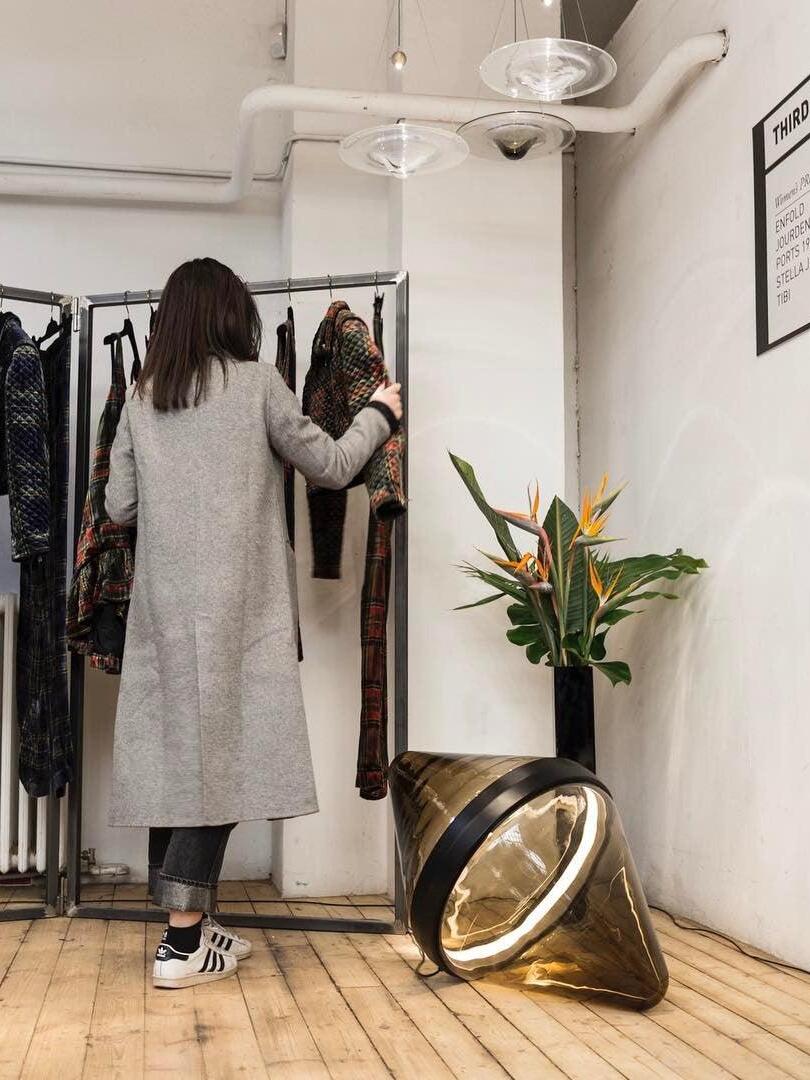 Two glass disc pendants above clothing display