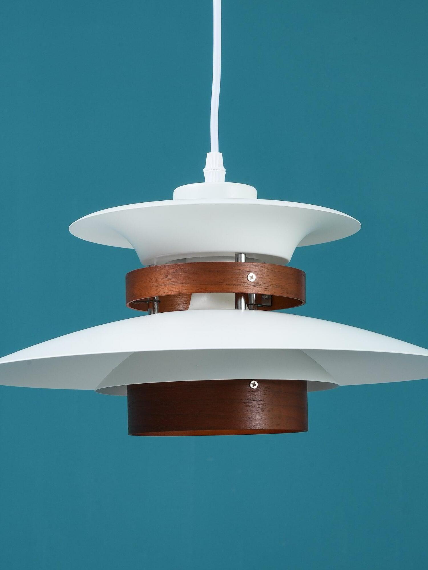 Close front view of dark wood cylinders between white shades