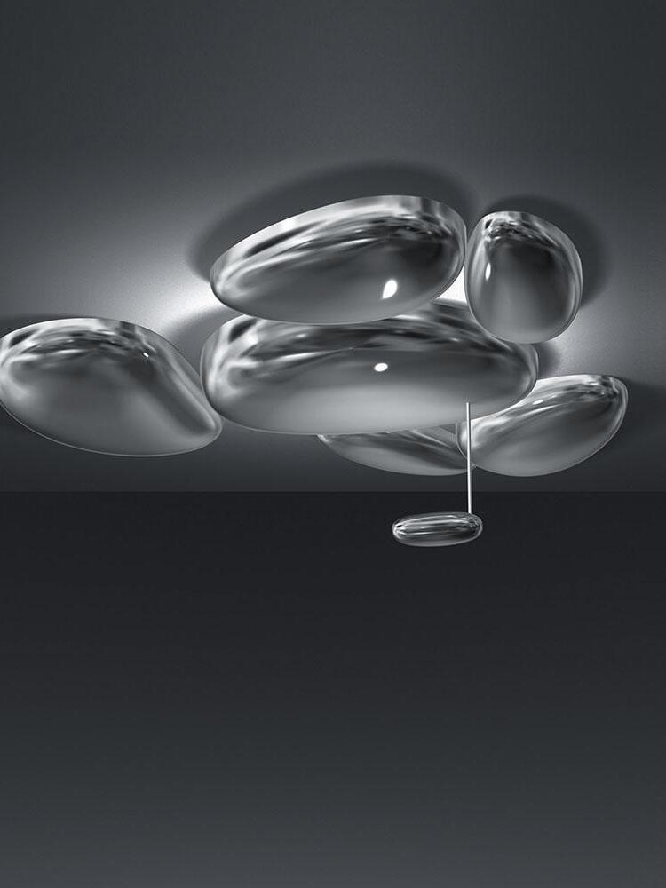 Reflective pebble cluster against dark background with small lower oval
