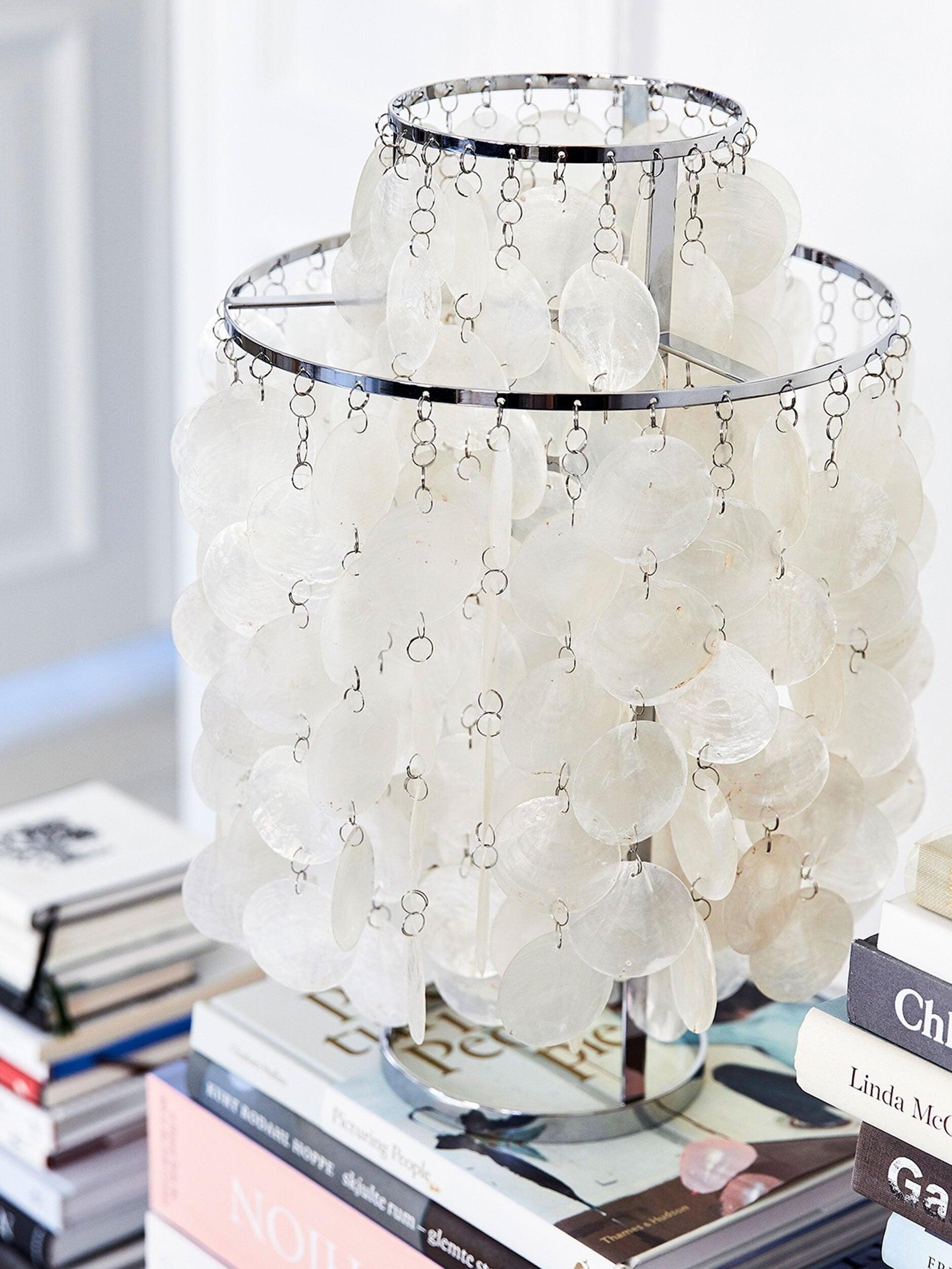 Angled top view of shell-disc lamp on stacked books