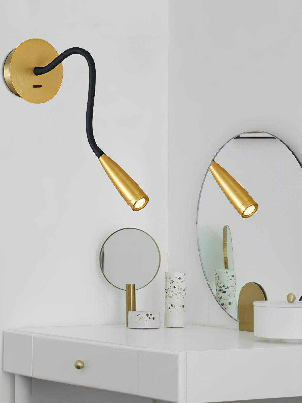Gold Flexi above a white vanity, with the illuminated head reflected in a mirror beside terrazzo accessories