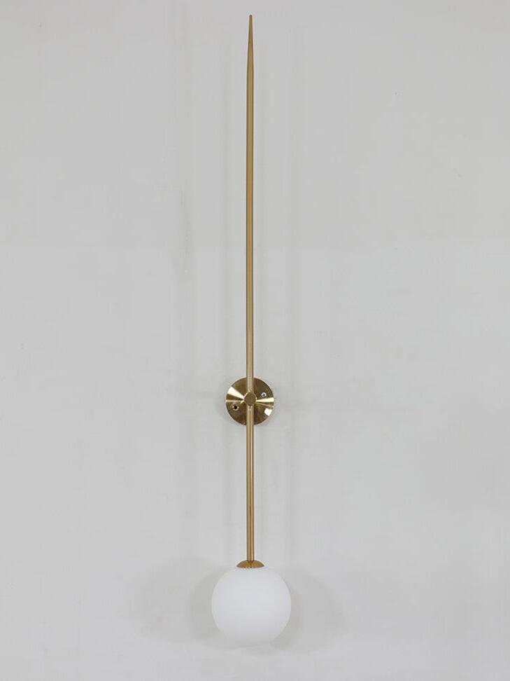 Frontal unlit gold-tone rod wall light with a round plate and white globe below