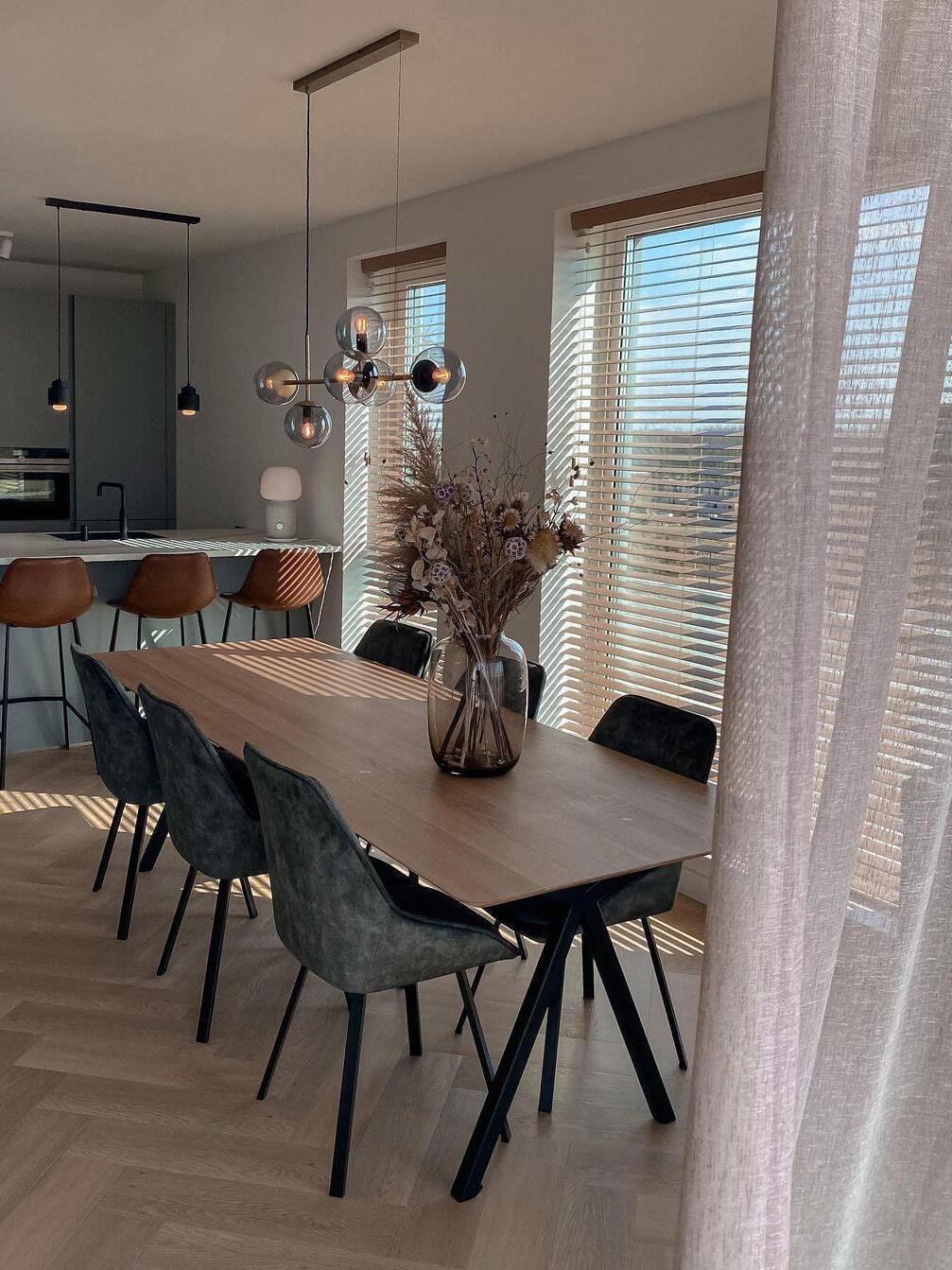 Linear chandelier with rectangular canopy over a dining table