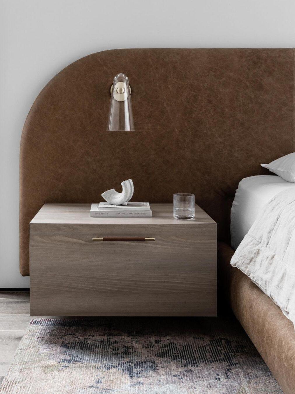 Small clear-glass wall light beside a bed