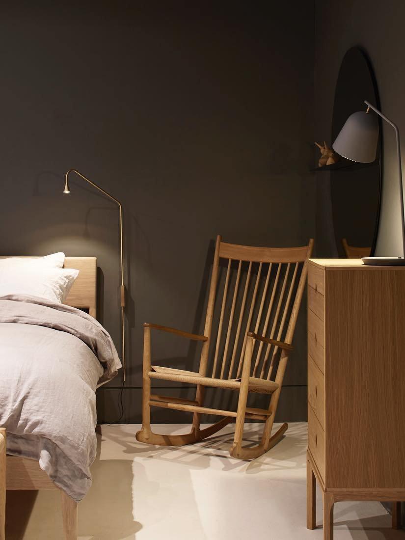 Golden wall light in a bedside reading area