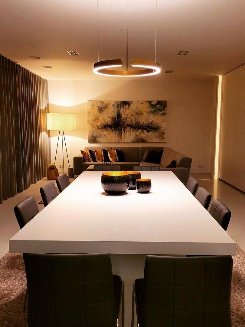 Single illuminated ring above a long white table