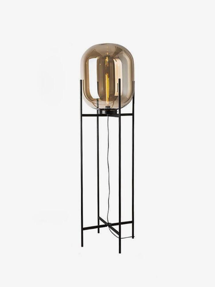 Oda glass floor lamp with an elongated rounded shade on a tall black metal frame.