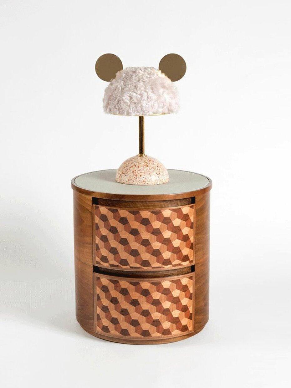 Pale plush shade table lamp on round patterned wood cabinet