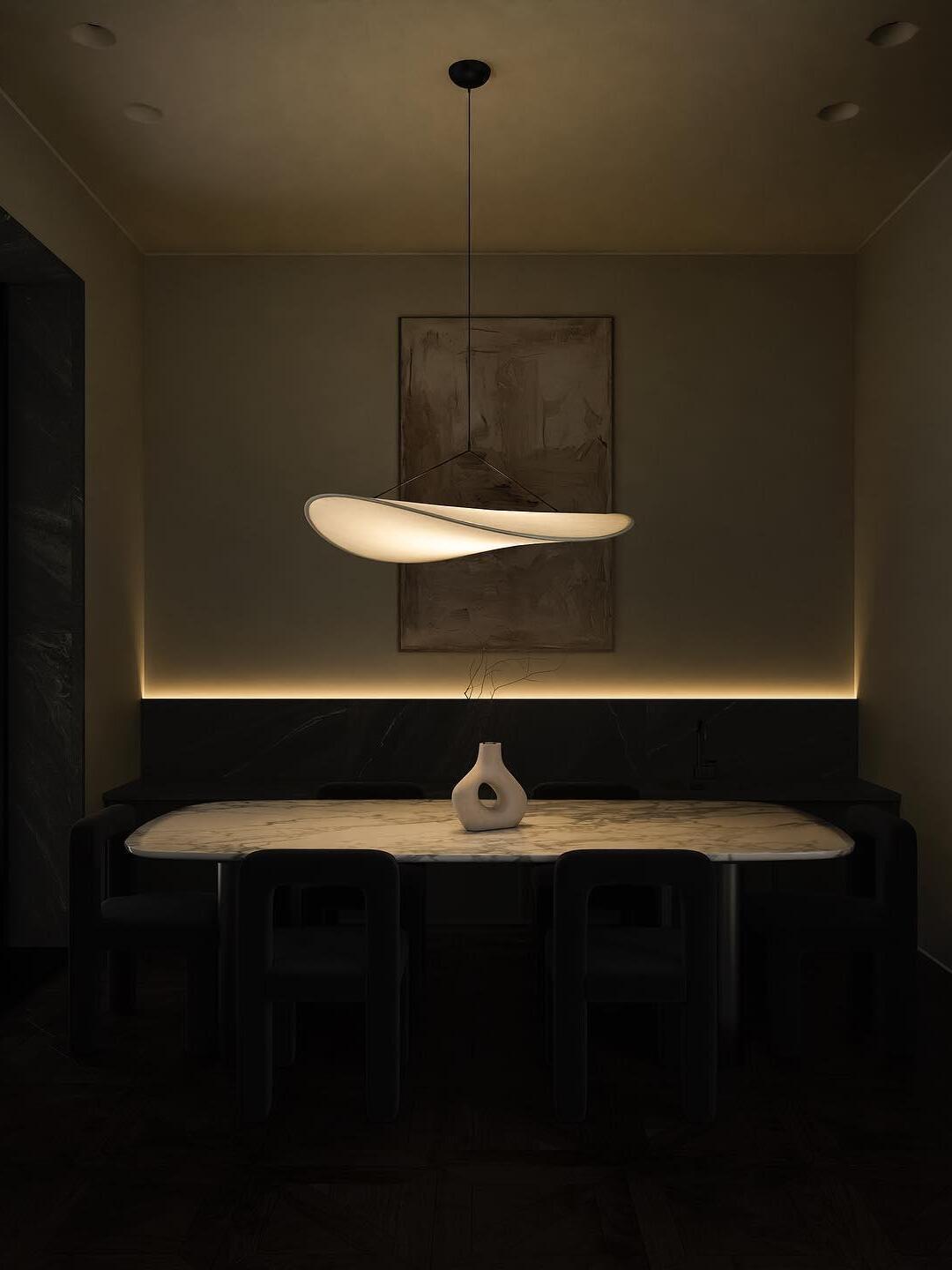 Illuminated Tense pendant above a dining table