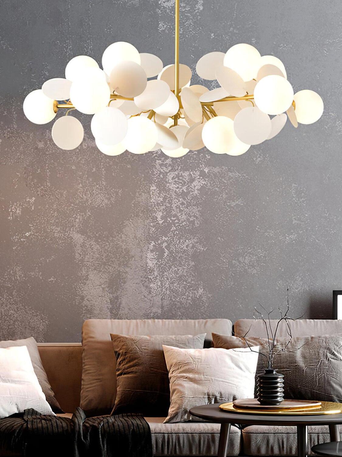 White globe and leaf-disc chandelier above a sofa