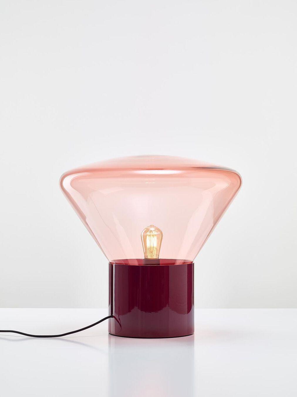Pale pink flared glass shade with bulb and glossy dark red base