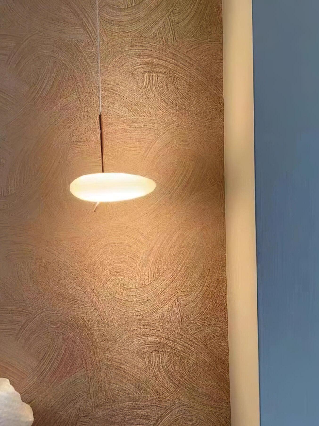 Small glowing white pebble-shaped pendant in front of a wood wall panel
