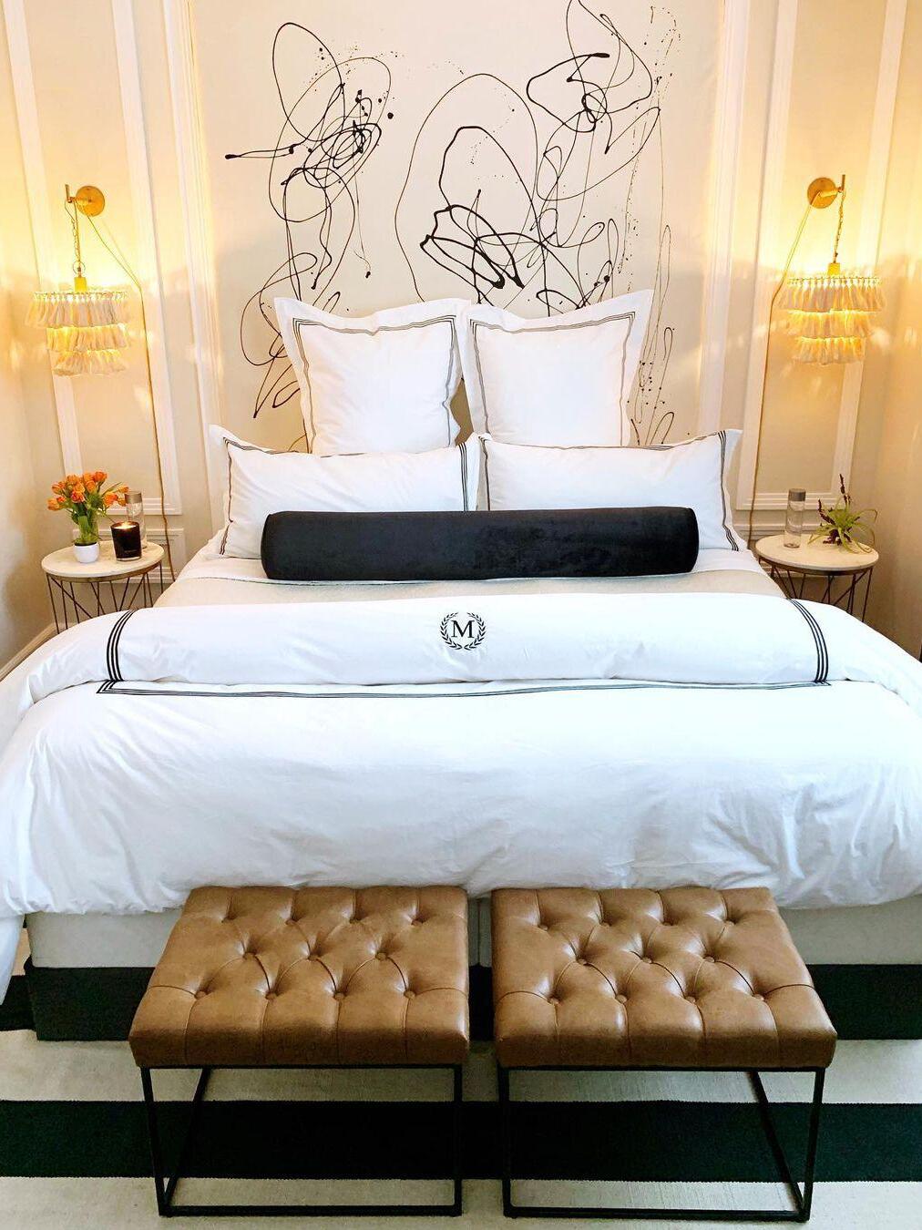 Paired tassel wall lights beside a large bed