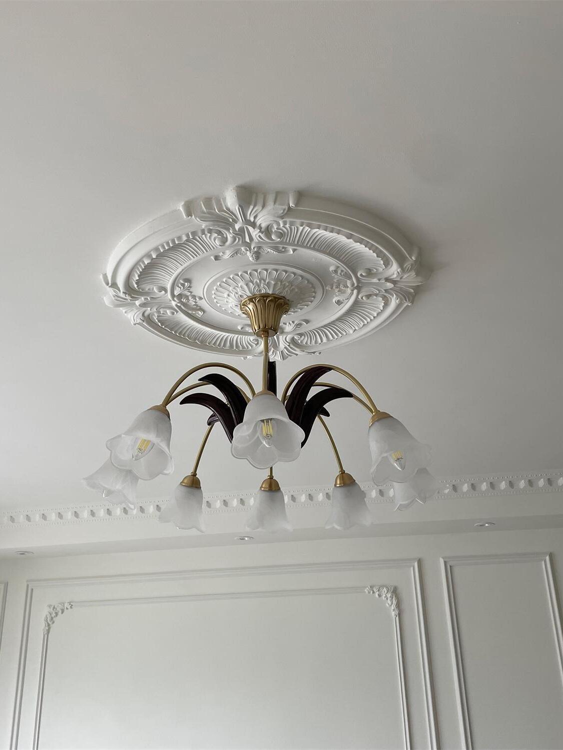 Floral chandelier below ornate ceiling medallion