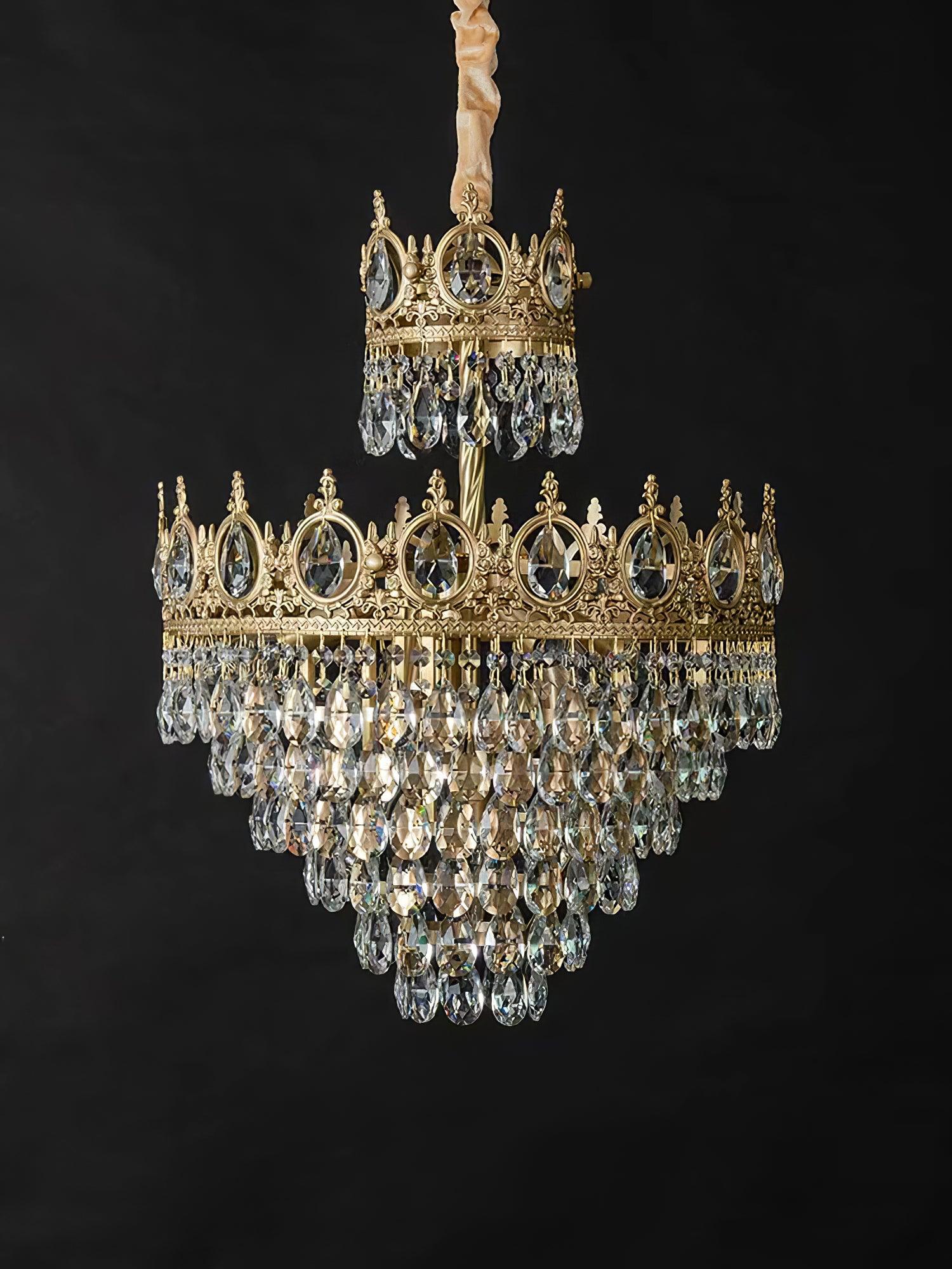 Crystal chandelier with a covered suspension and two ornate crown sections isolated against a dark background