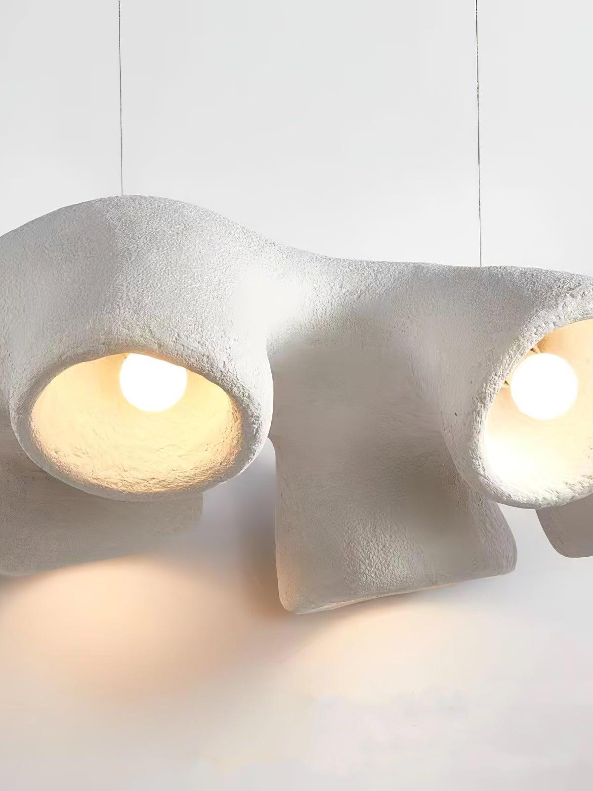 Close-up of white textured bell-like outlets with visible glowing round bulbs and a lower curved branch