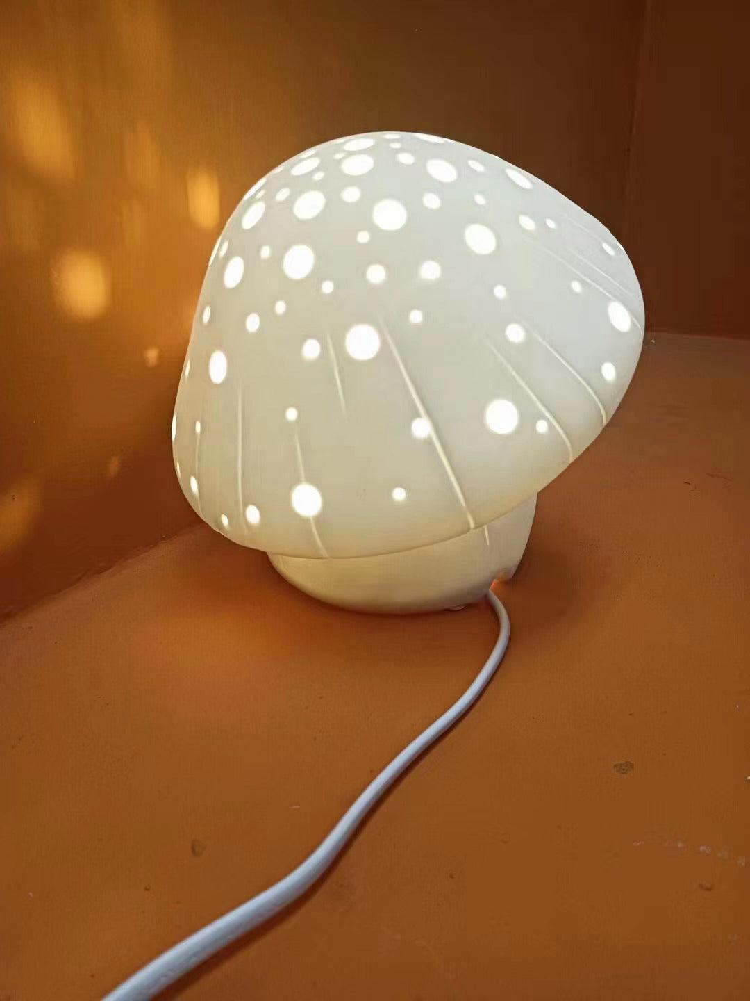 Opposite angled view of the lit perforated cap and white cord on an orange surface