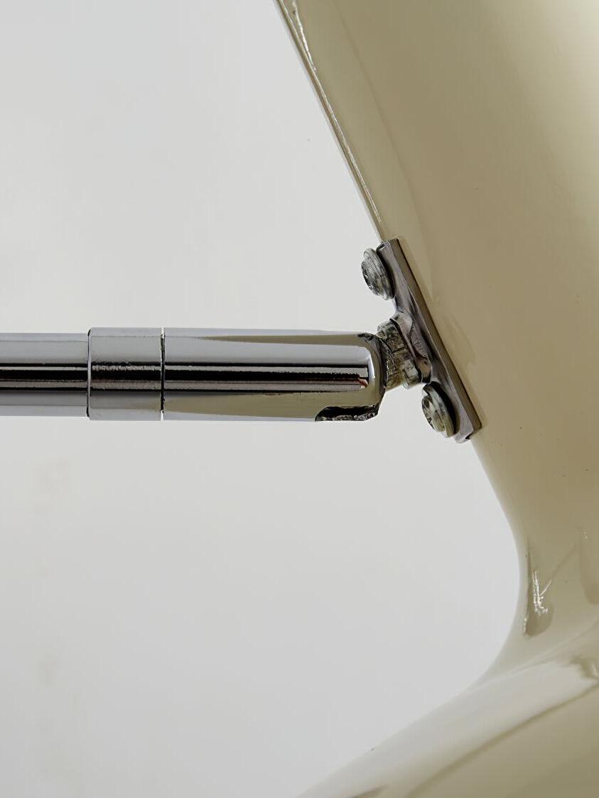 Close view of chrome joint behind cream shade