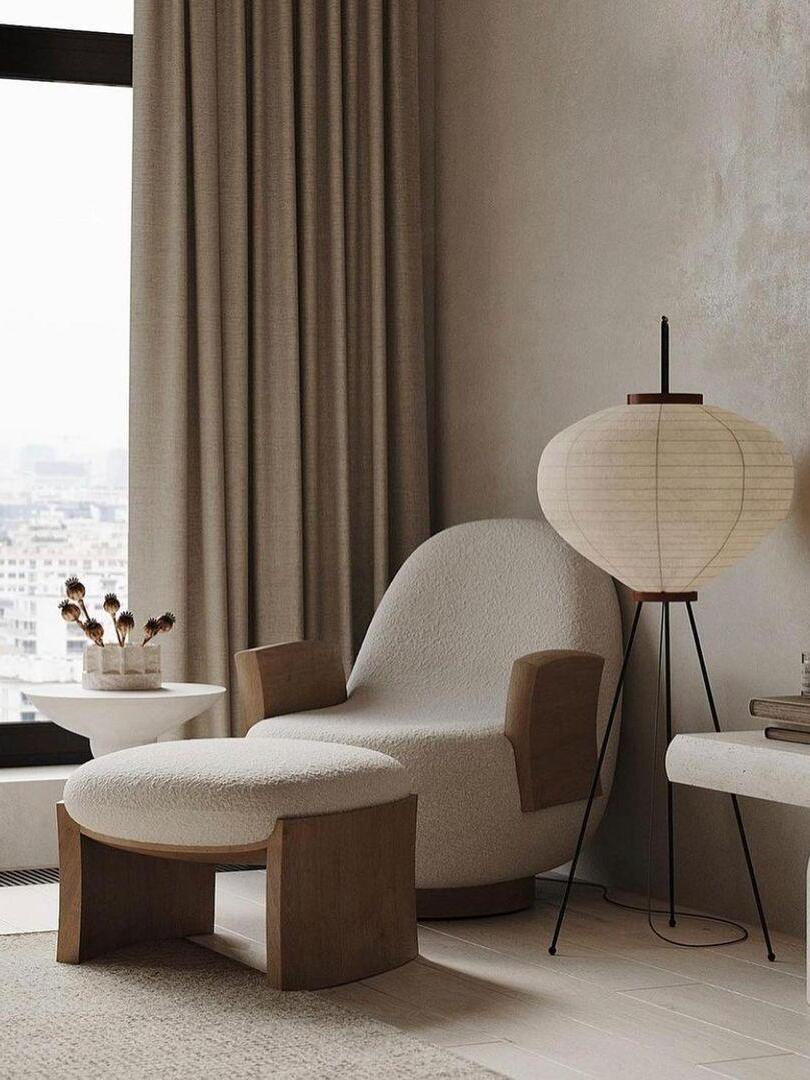 Paper floor lamp beside upholstered chair and curtains