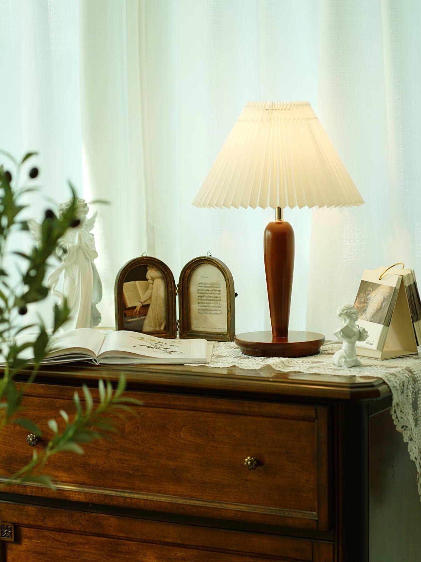 Brown lamp with plain shade among objects on dresser
